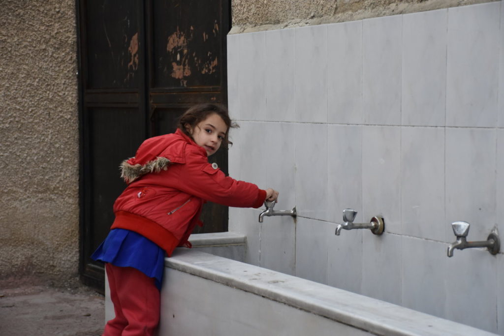 Bambina beve acqua dai rubinetti installati da Oxfam. Dania Kareh - Oxfam
